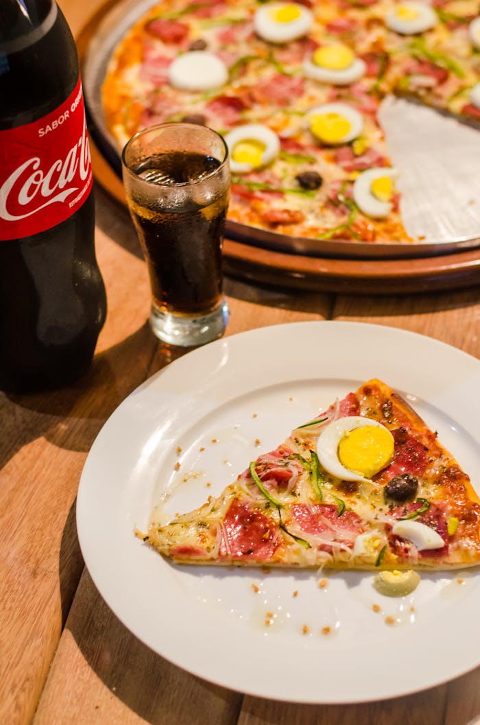 contact-bg Delicious pizza with eggs and olives, paired with a refreshing cola drink. Perfect for dine-in or casual dining.