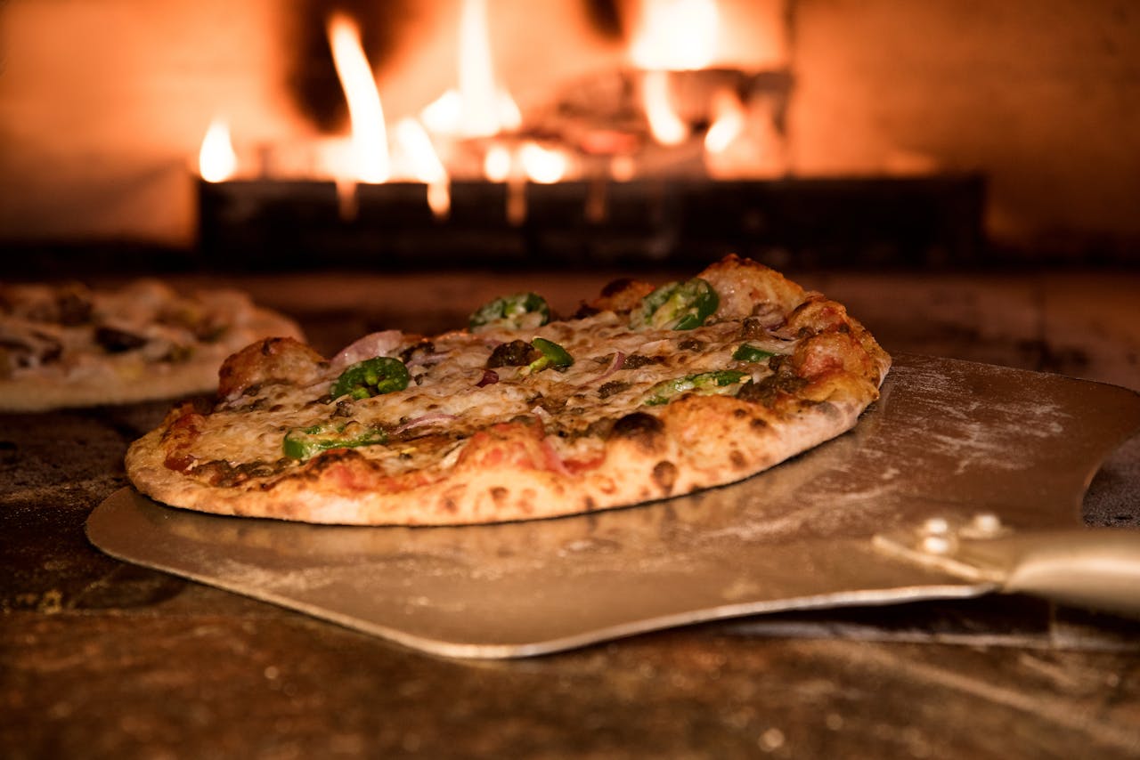 services-01 Appetizing gourmet pizza cooked in a wood-fired oven, showcasing artisanal toppings.